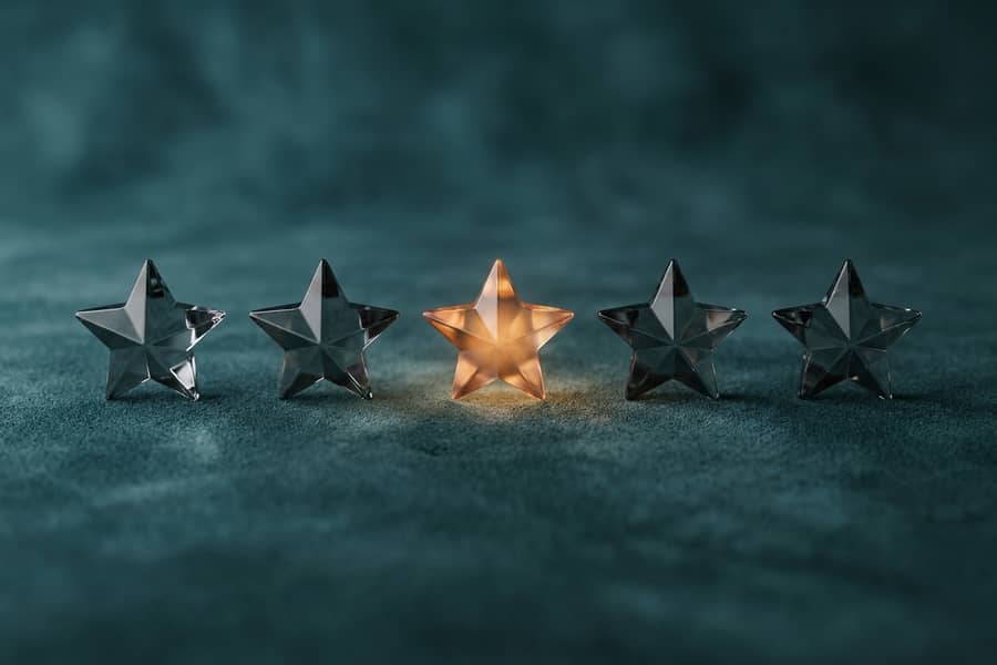 Five glass stars in a row, one glowing amber
