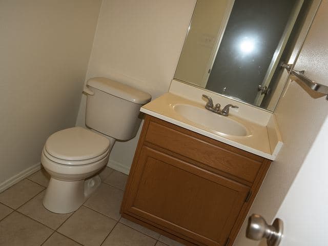Awkwardly framed bathroom listing photo with flash glare