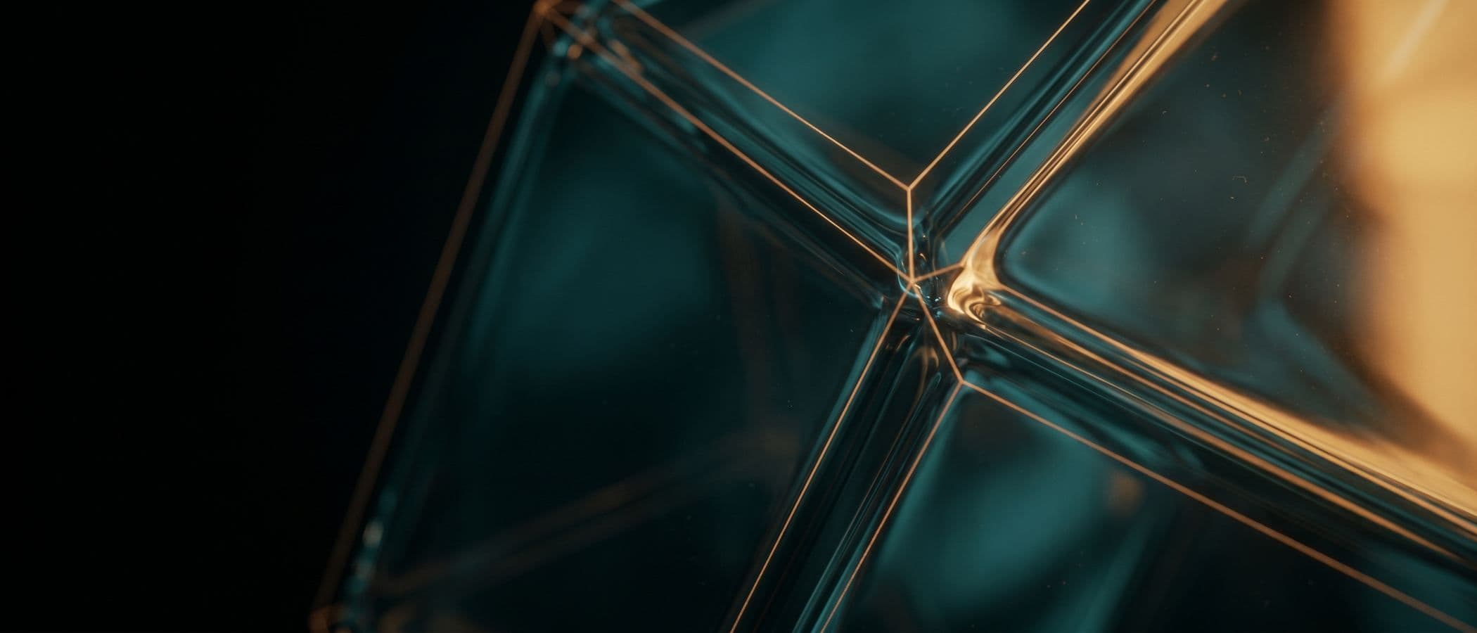 Abstract dark teal glass structure with warm amber edge light